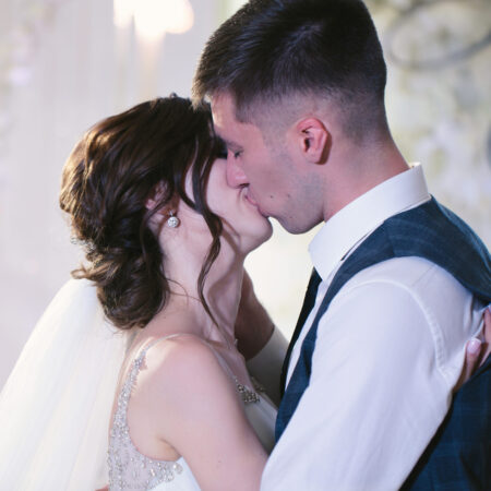 A happy wedding girl hugs and kisses in a restaurant.